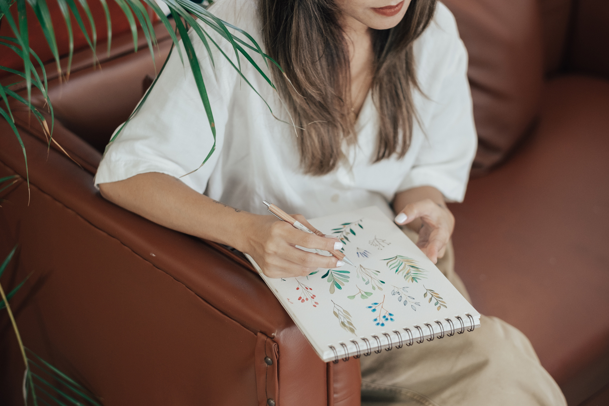 Female Designer Drawing in Notepad in Studio