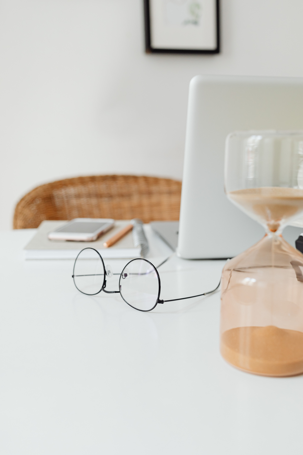  A Close-Up Shot of a Pair of Eyeglasses beside an Hourglass